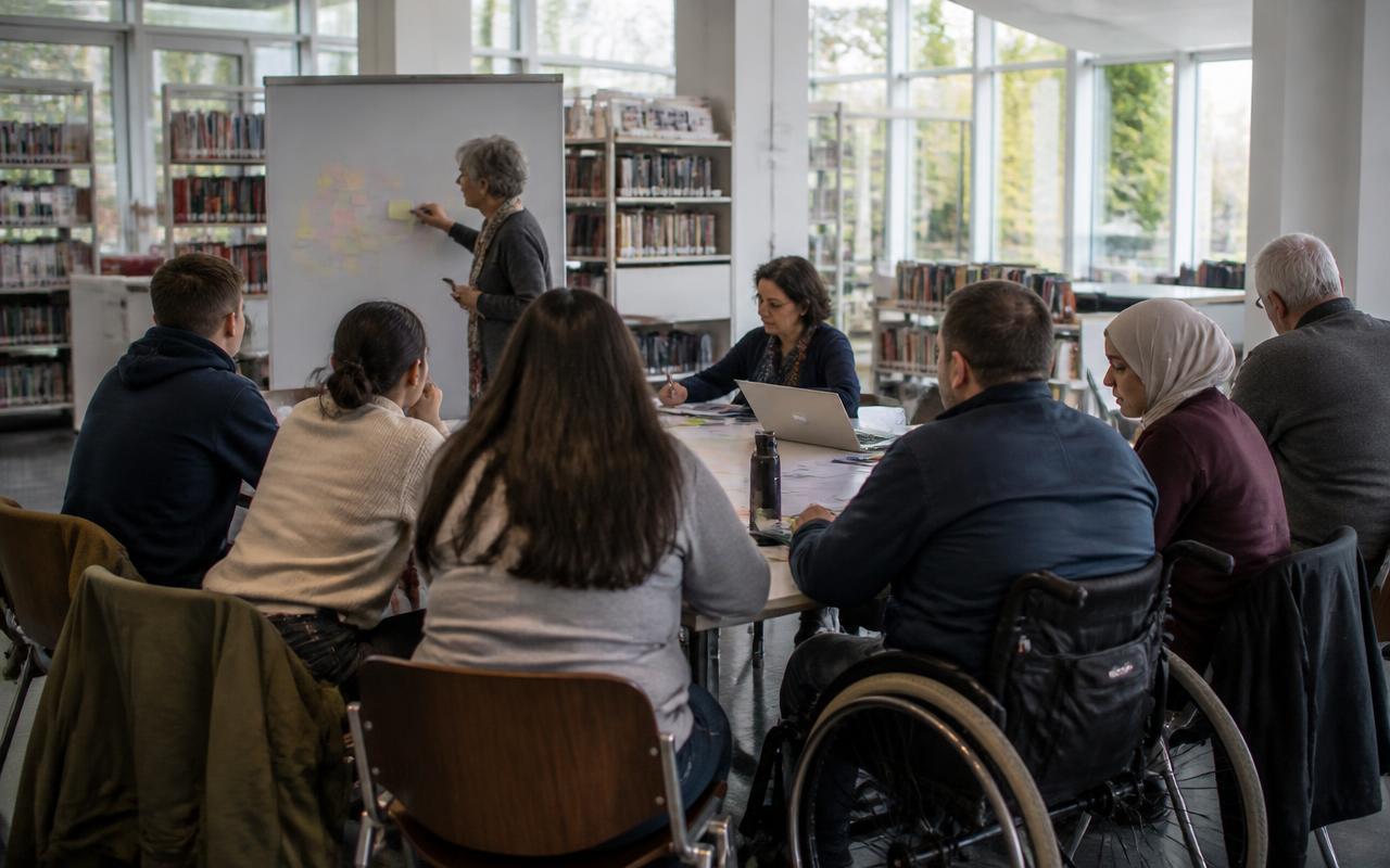 Woman facilitating an intergenerational workshop in a bright public library